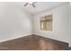 Bedroom features wood-look flooring, a ceiling fan, and a large window at 2250 E Deer Valley Rd # 26, Phoenix, AZ 85024