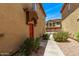 Inviting entrance to a townhome with a covered porch, desert landscaping, and a vibrant red door at 2250 E Deer Valley Rd # 26, Phoenix, AZ 85024
