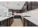 Contemporary kitchen featuring stainless steel appliances, dark cabinets, subway tile backsplash, and hardwood floors at 22938 E Calle Luna --, Queen Creek, AZ 85142