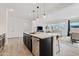 Open-concept kitchen featuring stainless steel appliances, a breakfast bar, dark wood cabinetry, and hardwood floors at 22938 E Calle Luna --, Queen Creek, AZ 85142
