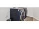 Modern laundry room featuring a sleek, navy blue GE washer and dryer set at 22938 E Calle Luna --, Queen Creek, AZ 85142