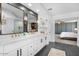 Modern bathroom featuring double sinks, white cabinetry, and a view into the adjacent bedroom at 2466 E Harrison Ct, Gilbert, AZ 85295