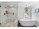 Bright bathroom showcasing a luxurious soaking tub, glass shower with marble tiles, and modern fixtures at 2466 E Harrison Ct, Gilbert, AZ 85295