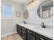 Bathroom with dual sinks and decorative mirrors above a black vanity with gold hardware at 2466 E Harrison Ct, Gilbert, AZ 85295