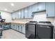 Spacious laundry room with blue cabinets, butcher block countertop, and gray tile flooring at 2466 E Harrison Ct, Gilbert, AZ 85295
