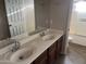 Bathroom with dual sinks, a large mirror, and a shower-tub combo at 24919 W Illini St, Buckeye, AZ 85326