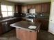 Functional kitchen featuring dark wood cabinets, stainless steel appliances, and a center island at 24919 W Illini St, Buckeye, AZ 85326