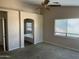Large main bedroom with ceiling fan and view into the ensuite bathroom at 24919 W Illini St, Buckeye, AZ 85326