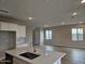 Open kitchen and living area featuring a large island, white cabinets, and stainless steel appliances at 3390 S 180Th Ln, Goodyear, AZ 85338