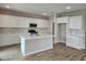 Open concept kitchen features white cabinets, stainless steel appliances, and wood look tile flooring at 3390 S 180Th Ln, Goodyear, AZ 85338
