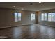 Spacious living room with wood-look tile flooring and bright natural light from the large windows at 3390 S 180Th Ln, Goodyear, AZ 85338