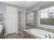 Bathroom with a glass door shower, garden tub, and a bright window at 3558 E Windsor Dr, Gilbert, AZ 85296