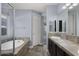 Bright bathroom featuring a soaking tub, dual vanity with dark cabinets, and tiled flooring at 3558 E Windsor Dr, Gilbert, AZ 85296