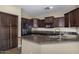 Modern kitchen boasts granite countertops, stainless steel appliances, and ample dark wood cabinetry at 3558 E Windsor Dr, Gilbert, AZ 85296