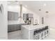 Modern kitchen with gray cabinets, stainless steel appliances, a large island with seating, and sleek tile flooring at 3608 W Morelos St, Chandler, AZ 85226