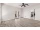 Spacious living room with wood-look floors, neutral walls, ceiling fan, and entrance into kitchen and backyard at 3608 W Morelos St, Chandler, AZ 85226
