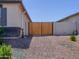 Gated backyard featuring gravel landscaping and greenery, providing privacy and a secure outdoor space at 37008 N Aleutian Dr, San Tan Valley, AZ 85143