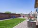 Inviting backyard featuring low-maintenance turf, gravel, and vibrant plants against a walled perimeter at 37008 N Aleutian Dr, San Tan Valley, AZ 85143
