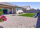 Expansive backyard with artificial grass, gravel landscaping, and patio seating, perfect for outdoor enjoyment at 37008 N Aleutian Dr, San Tan Valley, AZ 85143