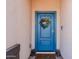 Inviting front entrance with a stylish blue door, decorative wreath, and welcome mat at 37008 N Aleutian Dr, San Tan Valley, AZ 85143