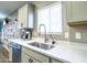 Close up of modern kitchen sink area with quartz countertops, grey cabinetry, and stainless steel dishwasher at 37008 N Aleutian Dr, San Tan Valley, AZ 85143