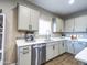 Bright kitchen featuring white cabinets, stainless steel appliances and fixtures, and wood-look tile flooring at 37008 N Aleutian Dr, San Tan Valley, AZ 85143