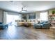 Bright and spacious living room with modern furniture, a ceiling fan, and sliding glass doors to patio at 37008 N Aleutian Dr, San Tan Valley, AZ 85143
