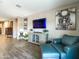Inviting living room featuring a comfortable armchair and ottoman, stylish decor, and wood-look tile flooring at 37008 N Aleutian Dr, San Tan Valley, AZ 85143