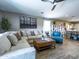 Bright living room featuring modern decor, a comfortable sectional sofa, and wood-look tile flooring at 37008 N Aleutian Dr, San Tan Valley, AZ 85143