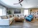 A cozy living room featuring a comfortable sectional sofa, a ceiling fan, and neutral décor at 37008 N Aleutian Dr, San Tan Valley, AZ 85143