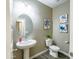 Stylish powder room with a pedestal sink, modern lighting, and decorative artwork at 37008 N Aleutian Dr, San Tan Valley, AZ 85143