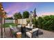 Picturesque backyard setting with a fire pit, lounge chairs, a well-maintained lawn, and charming string lights at 4613 S Rita Ln, Tempe, AZ 85282