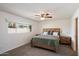 Bright bedroom with a wooden bed frame, ceiling fan, and a sunlit window, very cozy at 4613 S Rita Ln, Tempe, AZ 85282