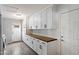 Bright laundry room features abundant white cabinetry and wood countertops, offering ample storage and workspace at 4613 S Rita Ln, Tempe, AZ 85282