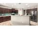 Spacious kitchen with dark wood cabinets, a kitchen island, and stainless-steel appliances at 5312 S 33Rd Ave, Phoenix, AZ 85041