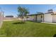 Backyard view features an expansive grassy area, mature trees, and a covered patio at 554 N Sunset Dr, Chandler, AZ 85225