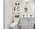 Bathroom featuring a toilet, sink, vanity, mirror, and storage cabinet at 554 N Sunset Dr, Chandler, AZ 85225