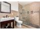 Cozy bathroom featuring a glass enclosed shower, earth-tone tile, and a single sink vanity at 554 N Sunset Dr, Chandler, AZ 85225