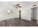Spacious bedroom featuring wood-look flooring, a ceiling fan and a window with natural light at 554 N Sunset Dr, Chandler, AZ 85225