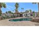 Backyard featuring a pool, palm trees, travertine pavers, and an outdoor kitchen area at 5612 E Emile Zola Ave, Scottsdale, AZ 85254