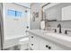 Bright bathroom featuring a shower over tub, tile backsplash, and white vanity with a stone countertop at 5612 E Emile Zola Ave, Scottsdale, AZ 85254