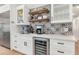 A well-appointed kitchen showcases a coffee bar with custom tile backsplash, beverage cooler, and open shelving at 5612 E Emile Zola Ave, Scottsdale, AZ 85254