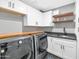 Modern laundry room with front load washer and dryer, built-in sink and butcher block folding surface at 5612 E Emile Zola Ave, Scottsdale, AZ 85254