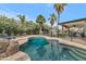 Sparkling pool area with lush landscaping, a rock feature, and shaded patio, perfect for outdoor relaxation and entertainment at 5612 E Emile Zola Ave, Scottsdale, AZ 85254