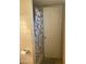 Full bathroom features a tiled shower with floral curtain, towel rack and beige tile at 6011 N 33Rd Ave, Phoenix, AZ 85017