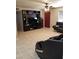 Spacious living room with tile floors, a ceiling fan, black couches, and a large media center at 6011 N 33Rd Ave, Phoenix, AZ 85017