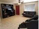 Spacious living room with tile floors, a ceiling fan, black couches, and a large media center at 6011 N 33Rd Ave, Phoenix, AZ 85017
