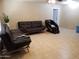 Living room with tile floors, ceiling fan, 2 black couches, and a black massage chair at 6011 N 33Rd Ave, Phoenix, AZ 85017