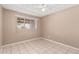 Neutral-toned bedroom with a ceiling fan, tile flooring, and window with natural light at 6334 N 37Th Ave, Phoenix, AZ 85019
