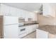 Bright kitchen featuring white cabinets and appliances, plus light countertops and flooring at 6334 N 37Th Ave, Phoenix, AZ 85019
